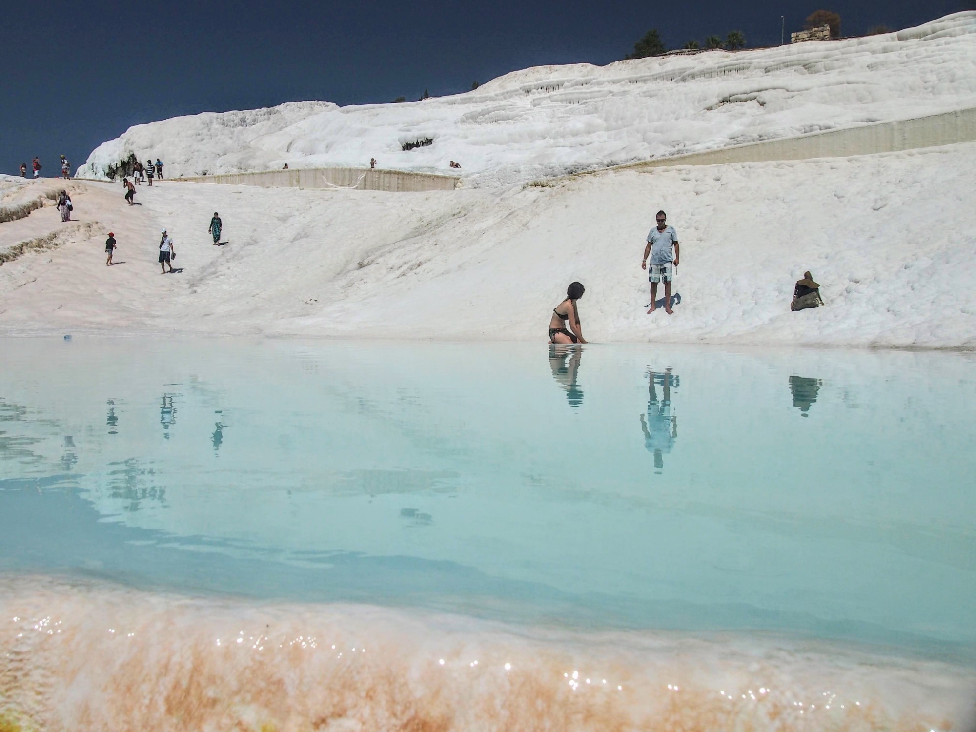People at Pamukkale, with white travertine and shallow pools