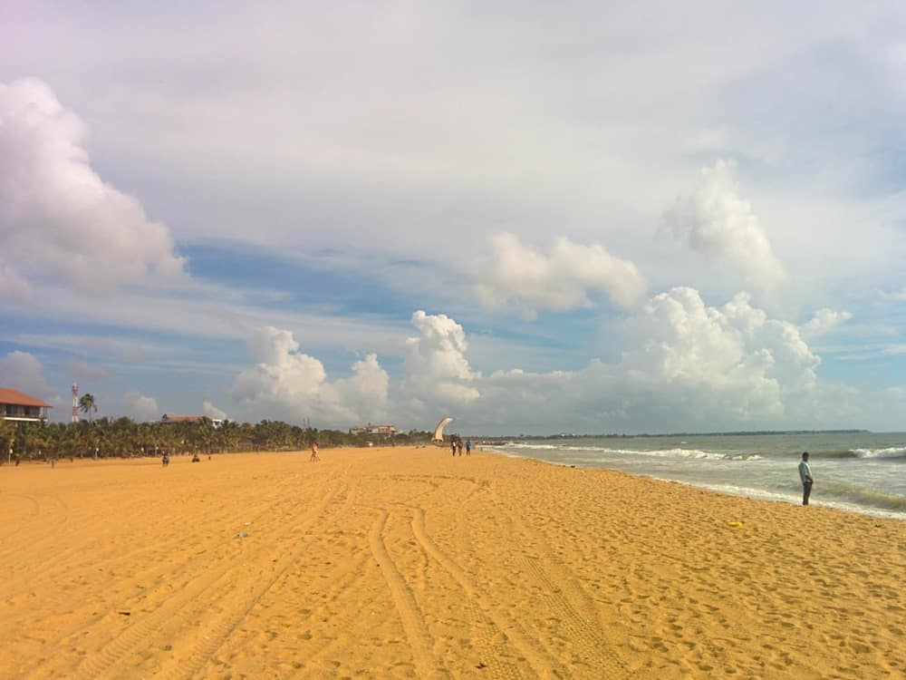 Long golden-sand beach at Negombo in Sri Lanka, with a few people on it