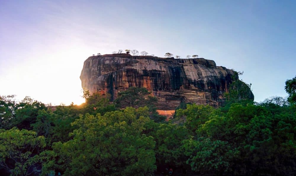 Sigiriya Rock, a very large rock with trees visible on the top.