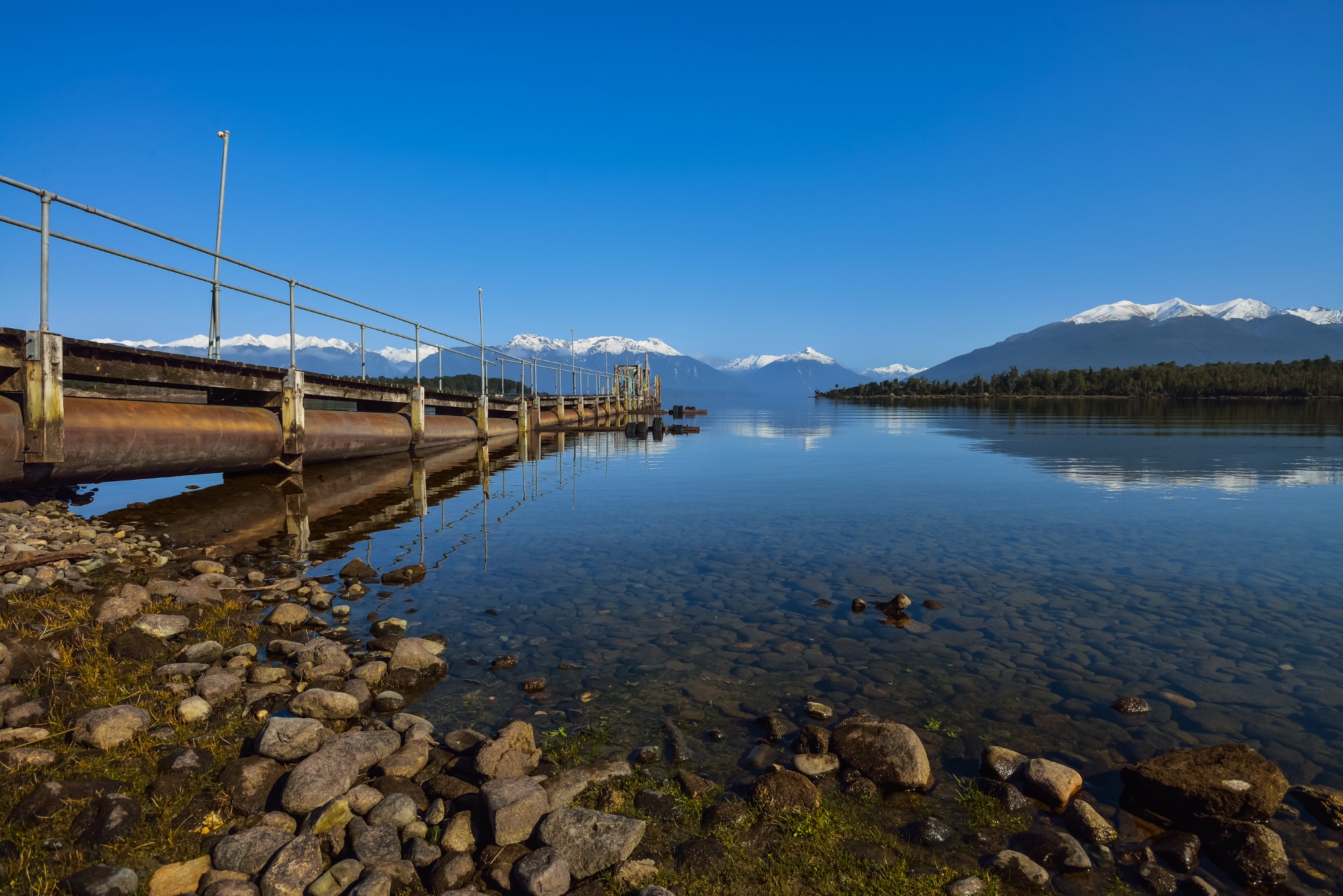 Jetty extending into a lake with mountains in background, Te Anau, New Zealand