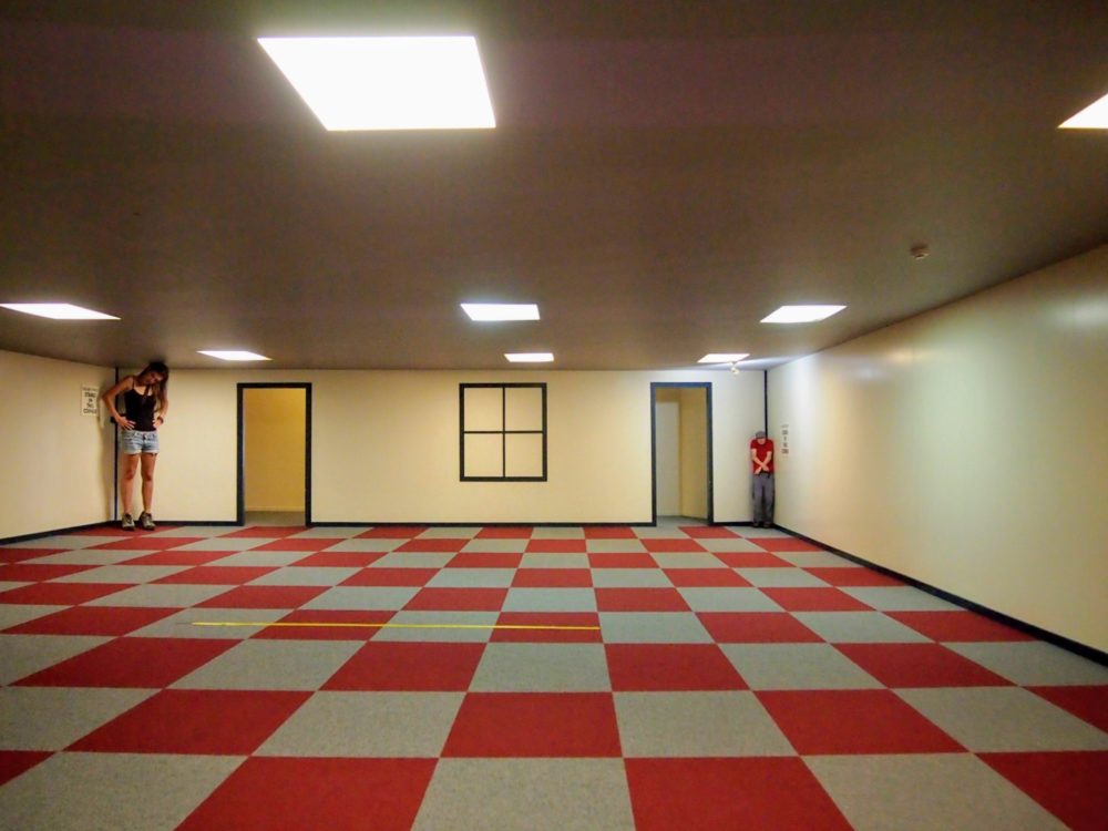 Optical illusion room at Puzzling World, Wanaka, with two people inside