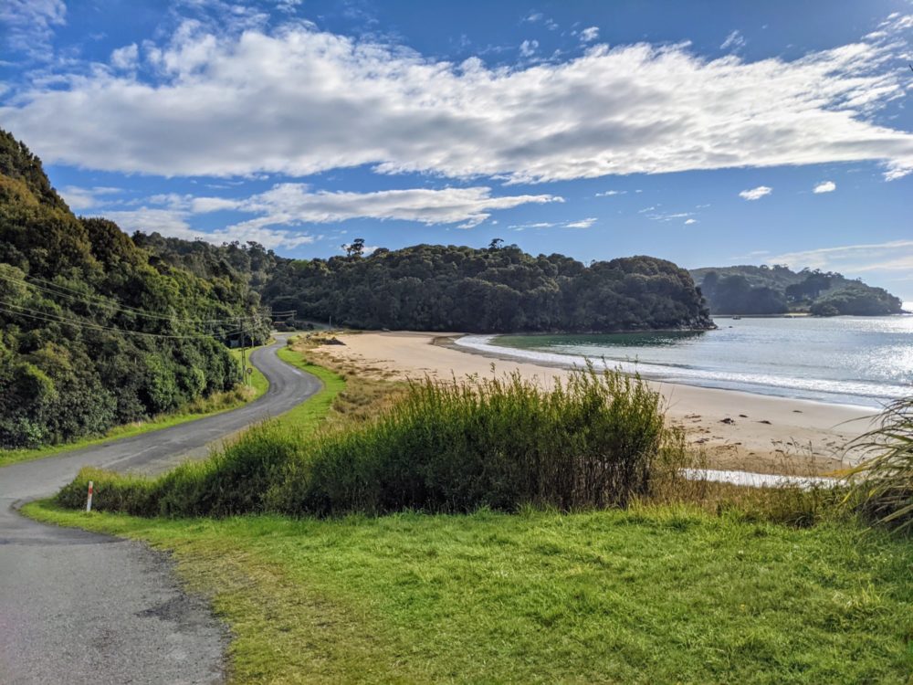 Road outside Oban on Stewart Island, with beach and ocean in background