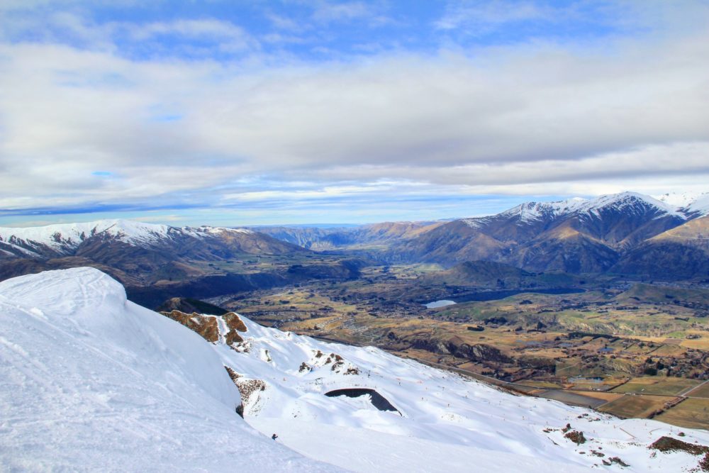 View from snow-covered mountain over valley and lake near Queenstown, New Zealand