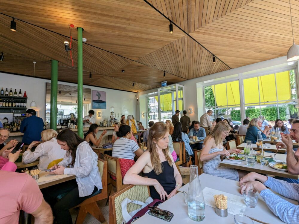 Interior view of packed restaurant with wooden roof