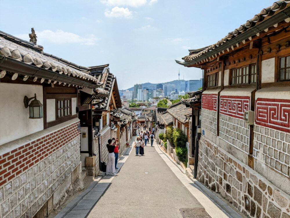 Traditional Korean buildings lining both sides of a narrow alleyway at Bukchon Hanok Village in Seoul