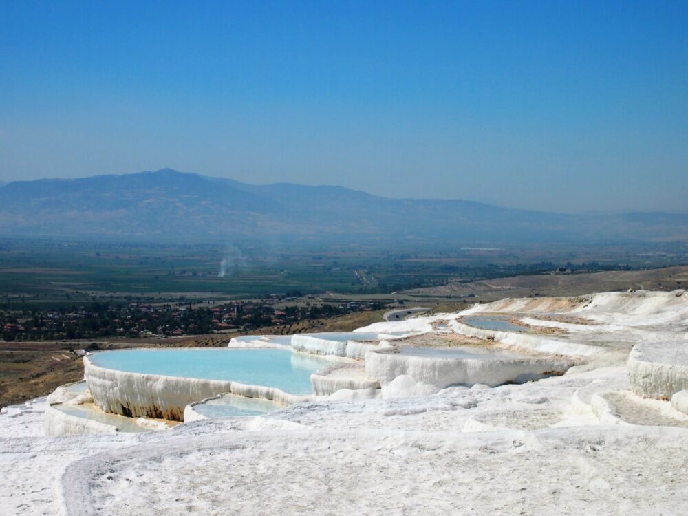 Wide overview of the travertine at Pamukkale with many man-made pools